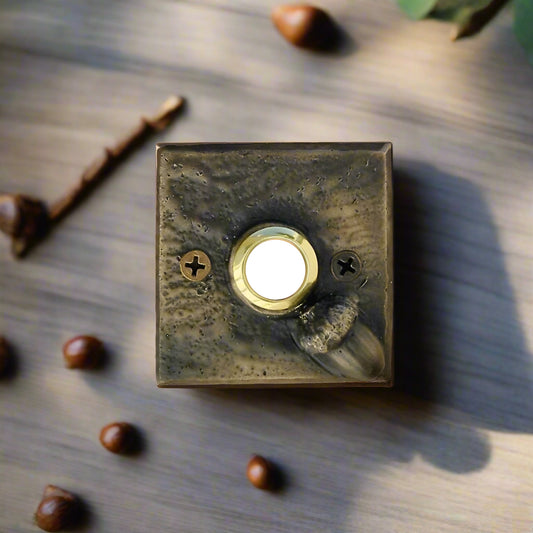 Square bronze doorbell plate with acorn in lower right corner