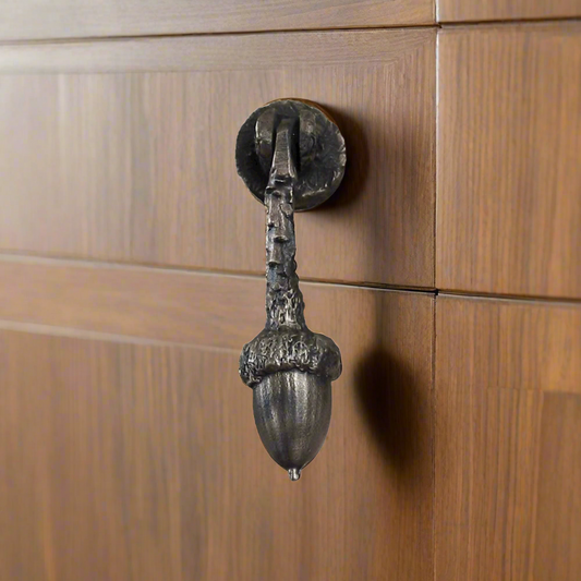 Bronze cabinet hanging hinged pull with one acorn on the end of a branch.