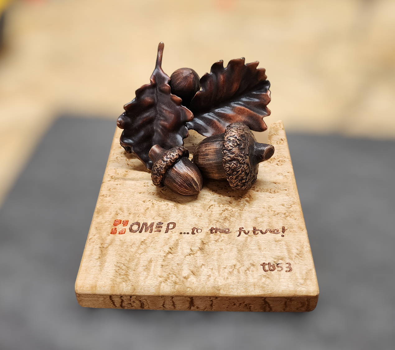 Bronze Art with acorns and oak leaves on a wood plaque.
